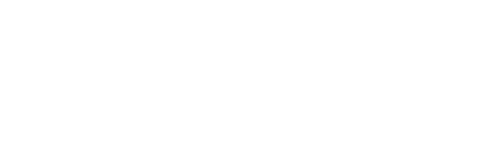 A person in a red uniform stands on a field, holding a basketball while looking toward a teammate during a game.