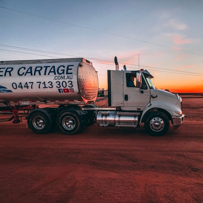 White Tanker Truck on Red Dirt Road at Sunset — Highlands Water Cartage in Wagga Wagga, NSW