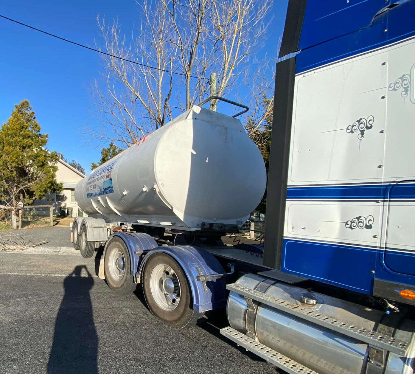 White tanker truck with blue accents parked on a street — Highlands Water Cartage in Glenquarry, NSW