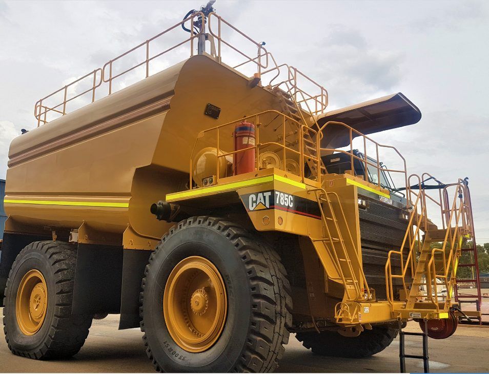 Yellow water truck, Caterpillar 785C, used for dust suppression in a mining setting — Highlands Water Cartage in Glenquarry, NSW