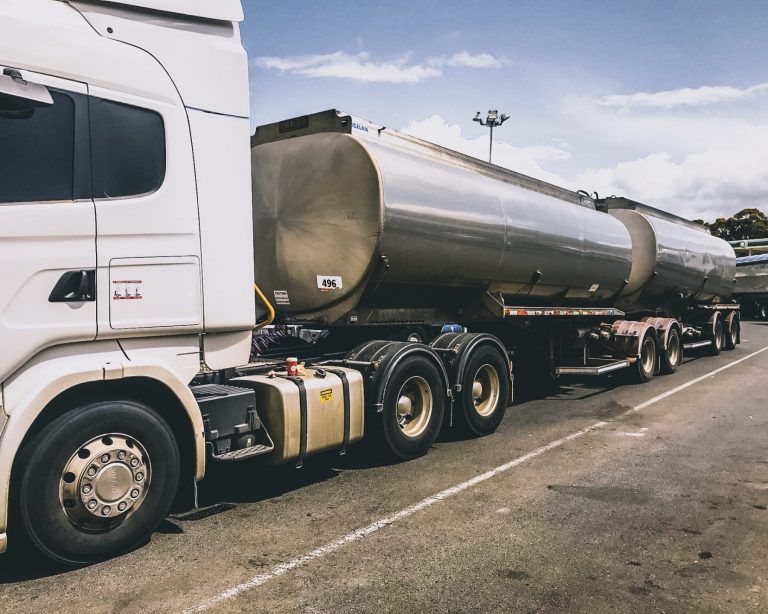 White semi-truck with two silver tanker trailers parked on asphalt — Highlands Water Cartage in Glenquarry, NSW