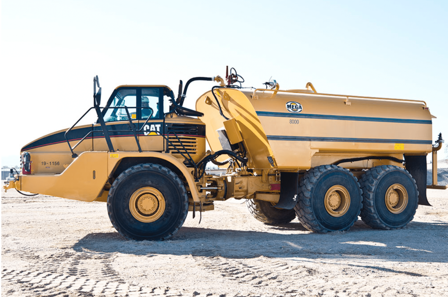 Yellow Caterpillar water truck on a construction site; spraying water — Highlands Water Cartage in Glenquarry, NSW
