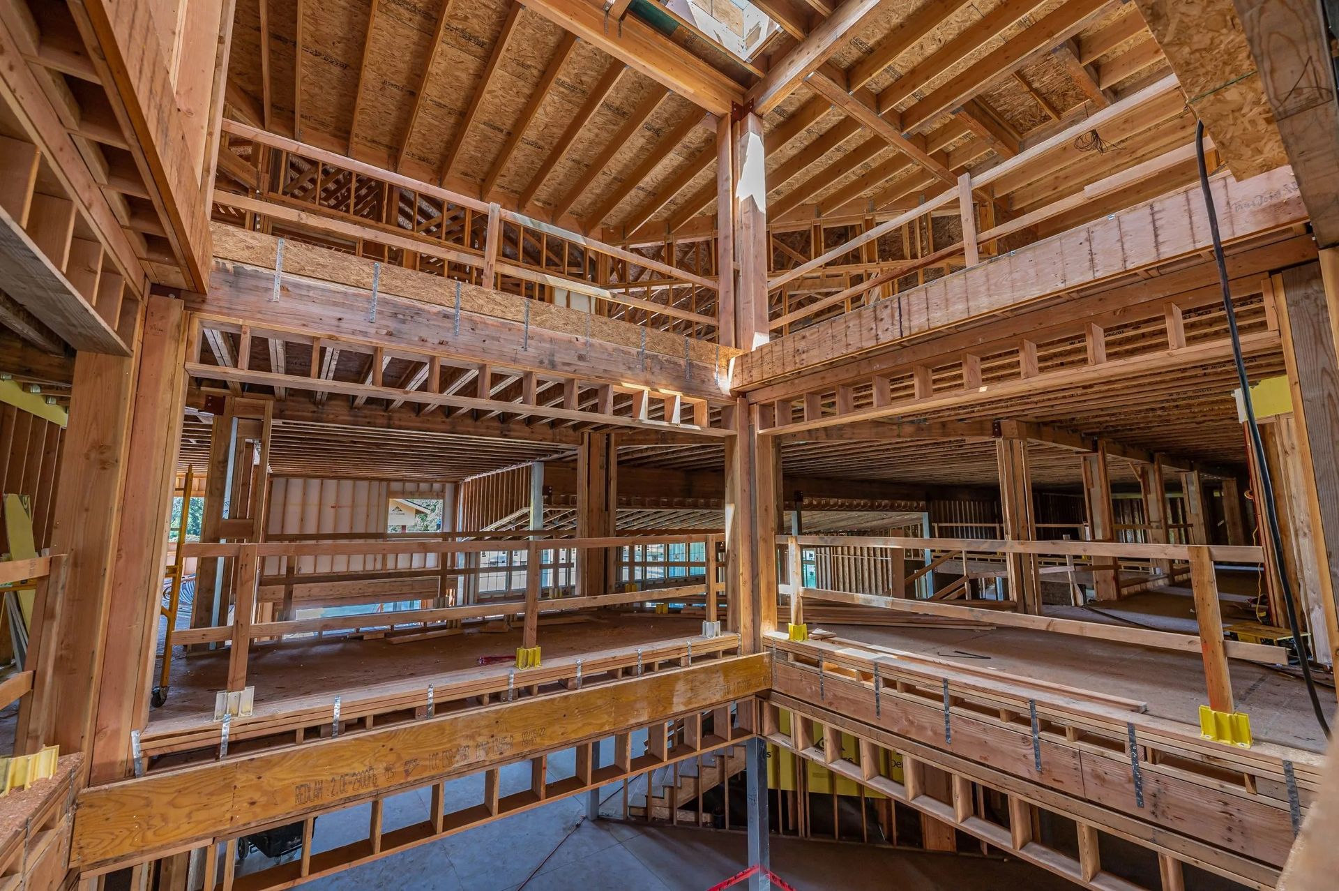 Interior of a large unfinished wooden building with exposed beams and multiple open floors