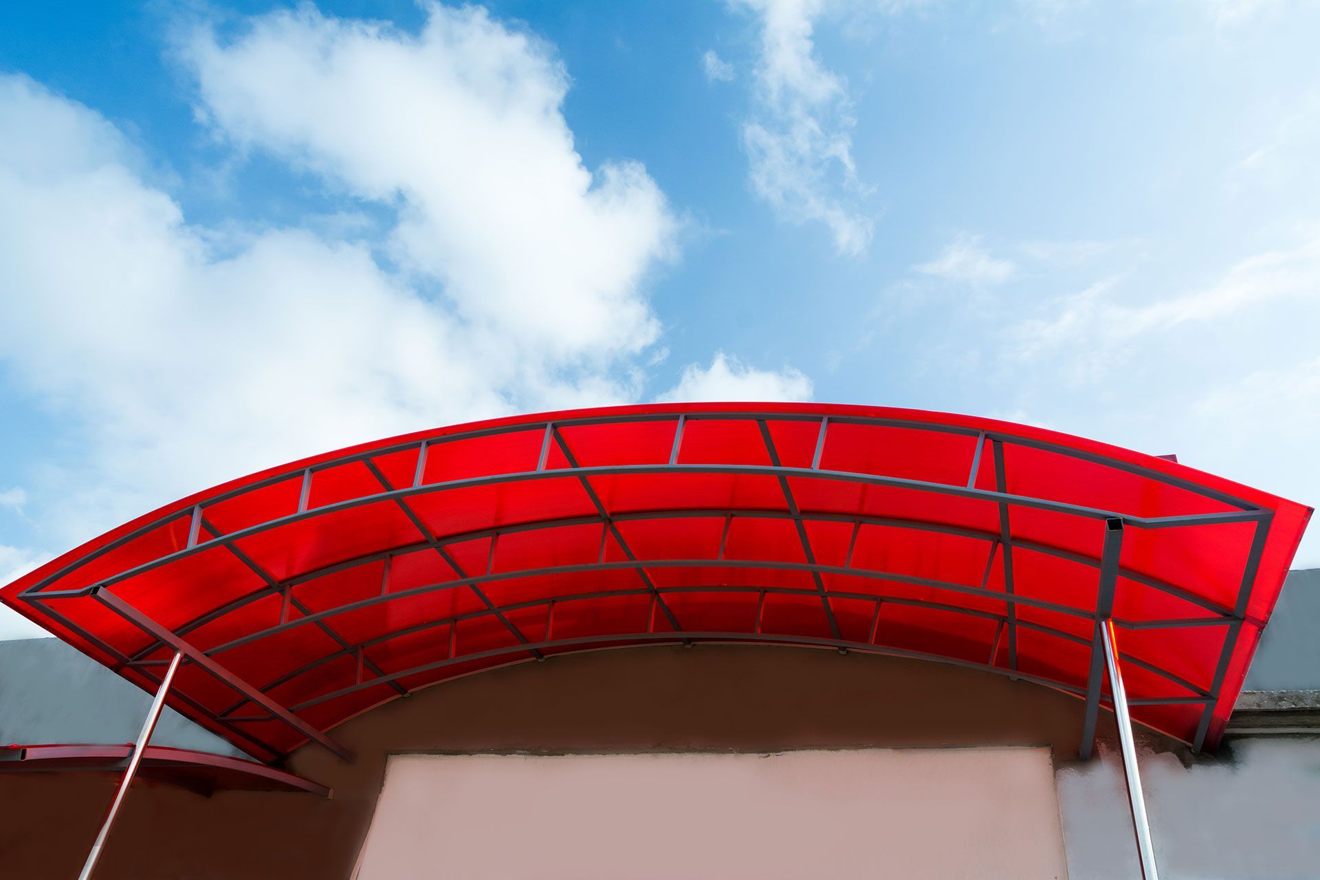 Red canopy awning with curved metal frame providing sun protection
