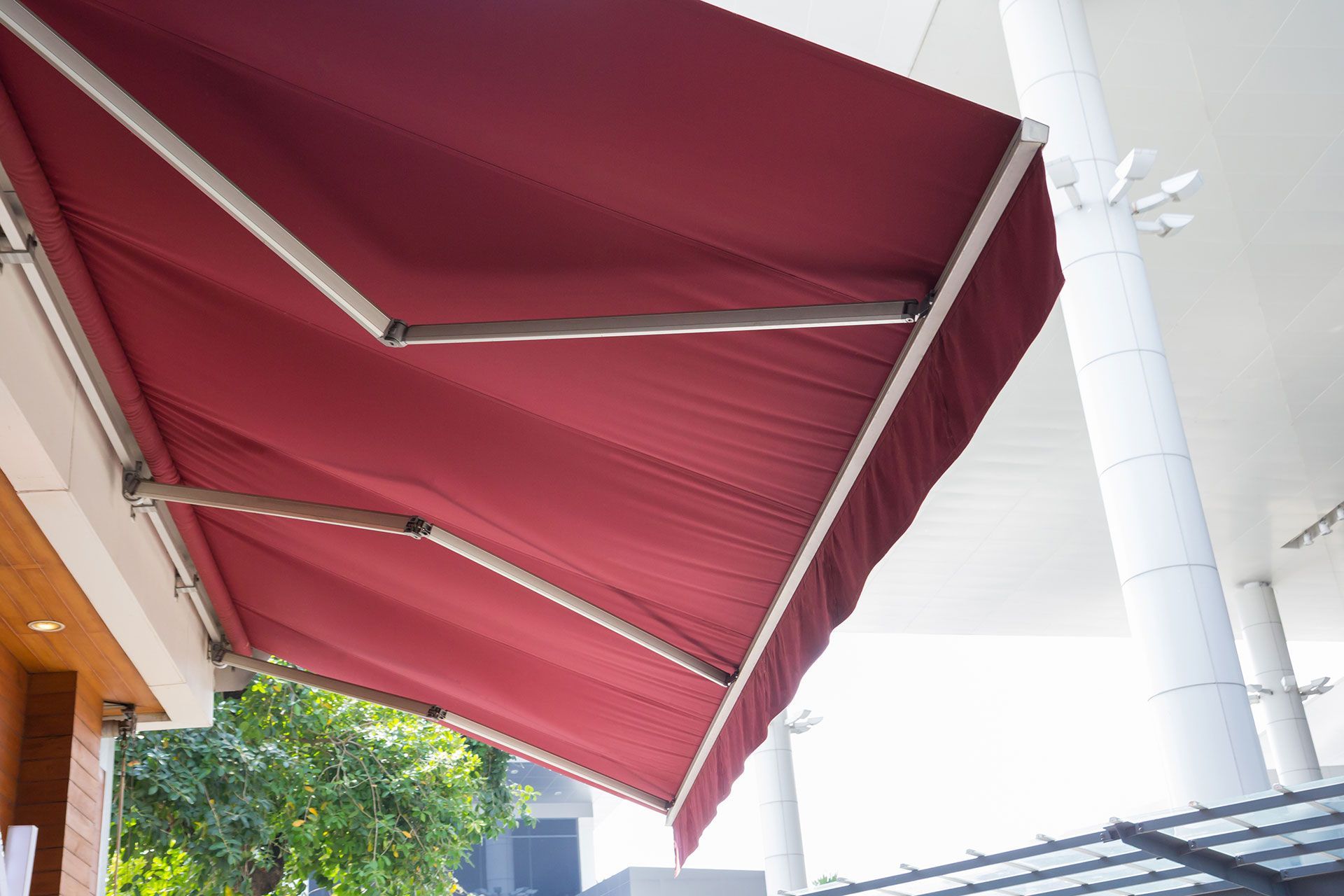 Red motorised fabric awning with aluminium frame