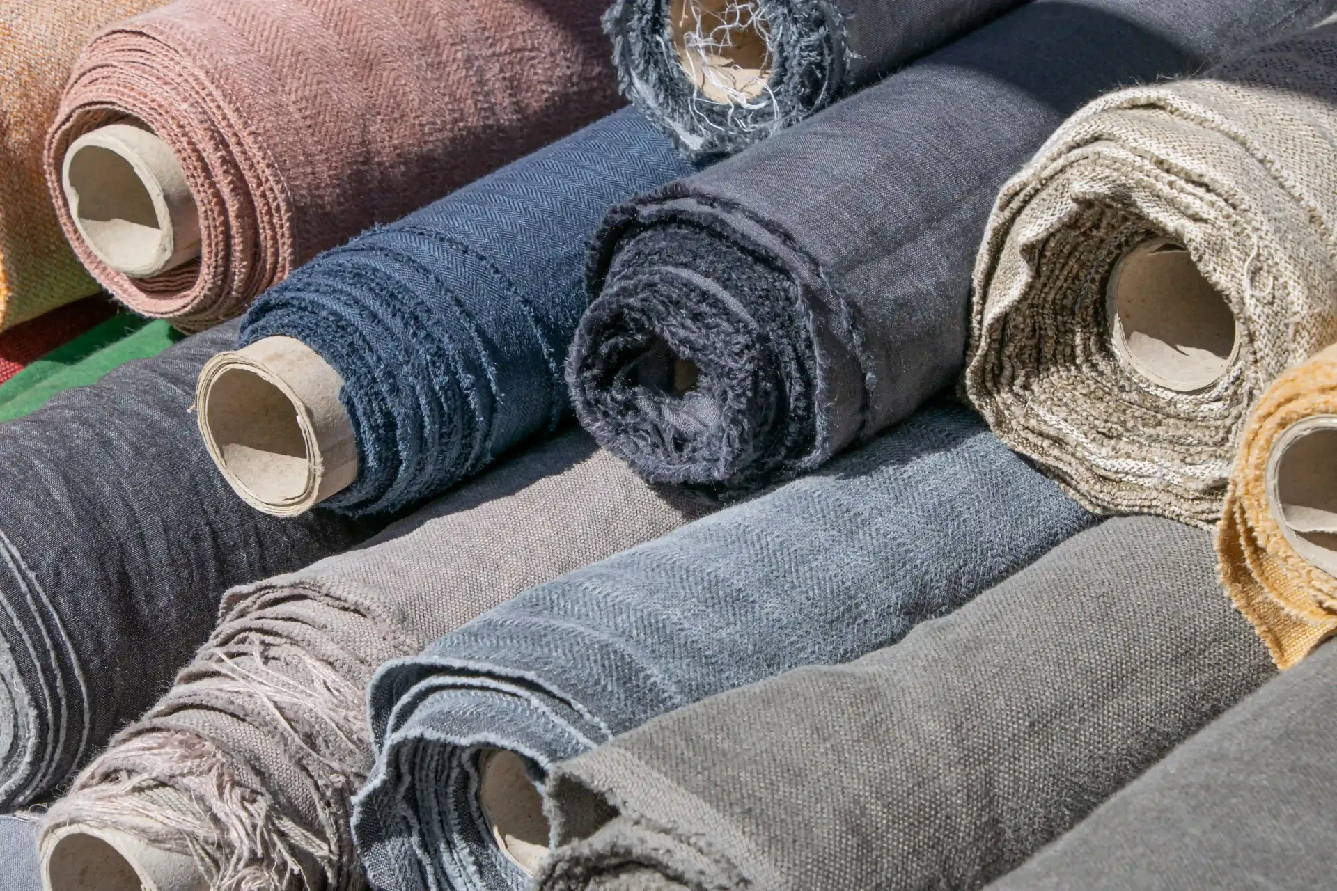 Rolls of fabric in various colors at a canvas awning supplier warehouse.