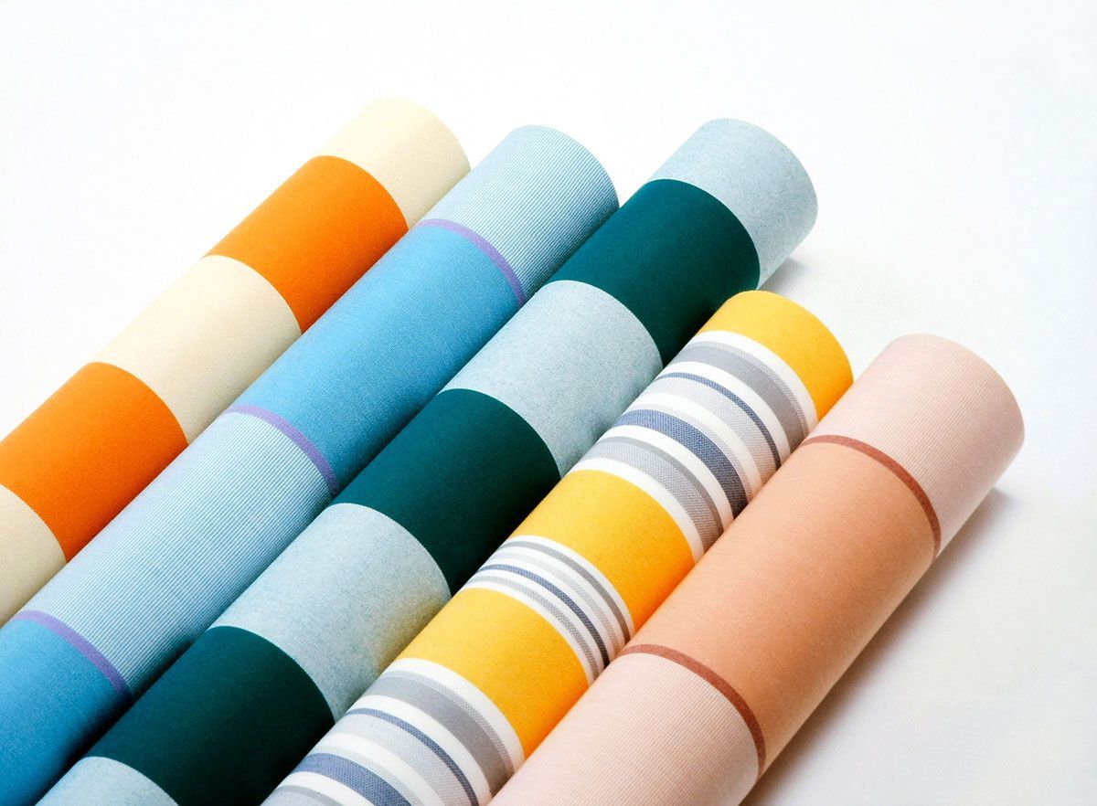 Various rolls of fabric illustrating different awning material types in Malaysia.
