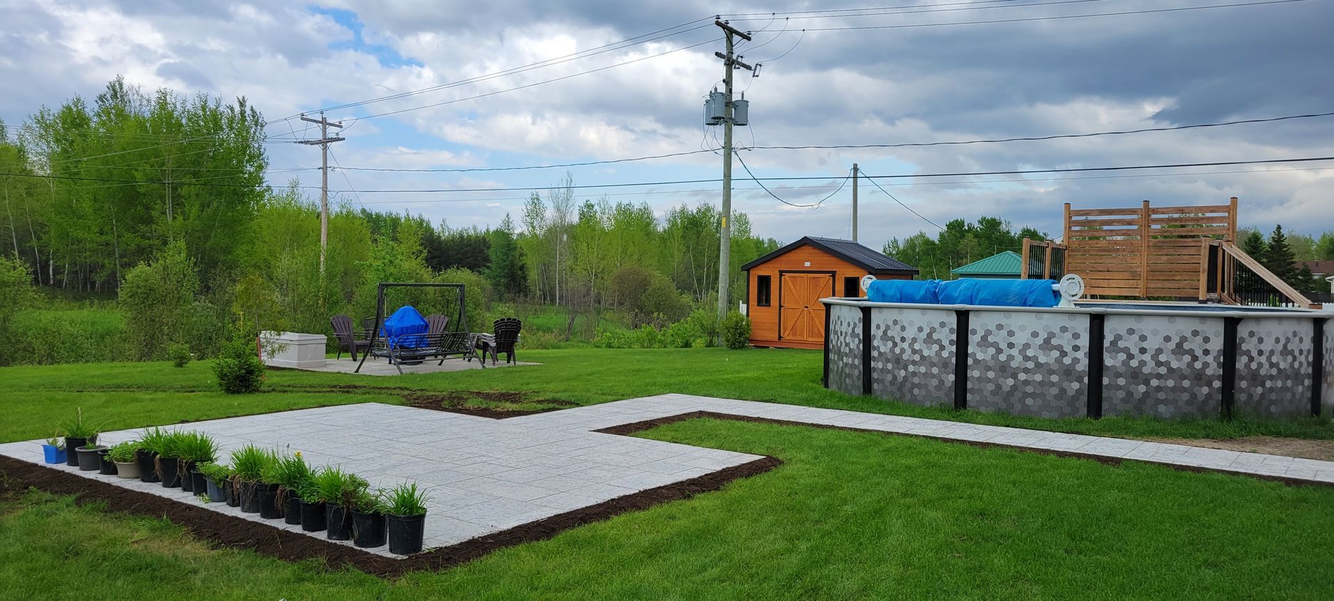 Une cour arrière avec une piscine et un cabanon en arrière-plan.
