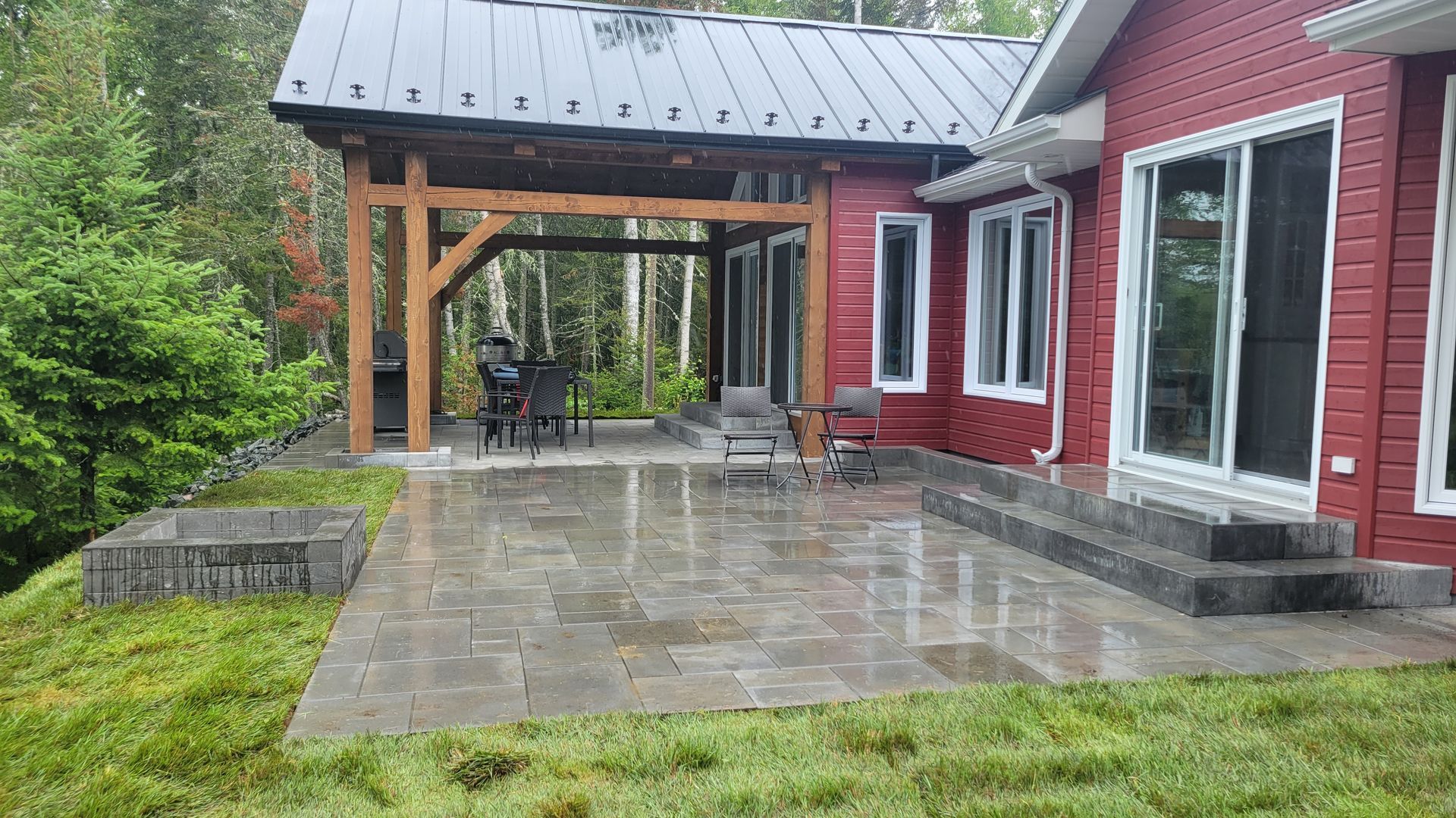 Une maison rouge avec un grand patio devant.