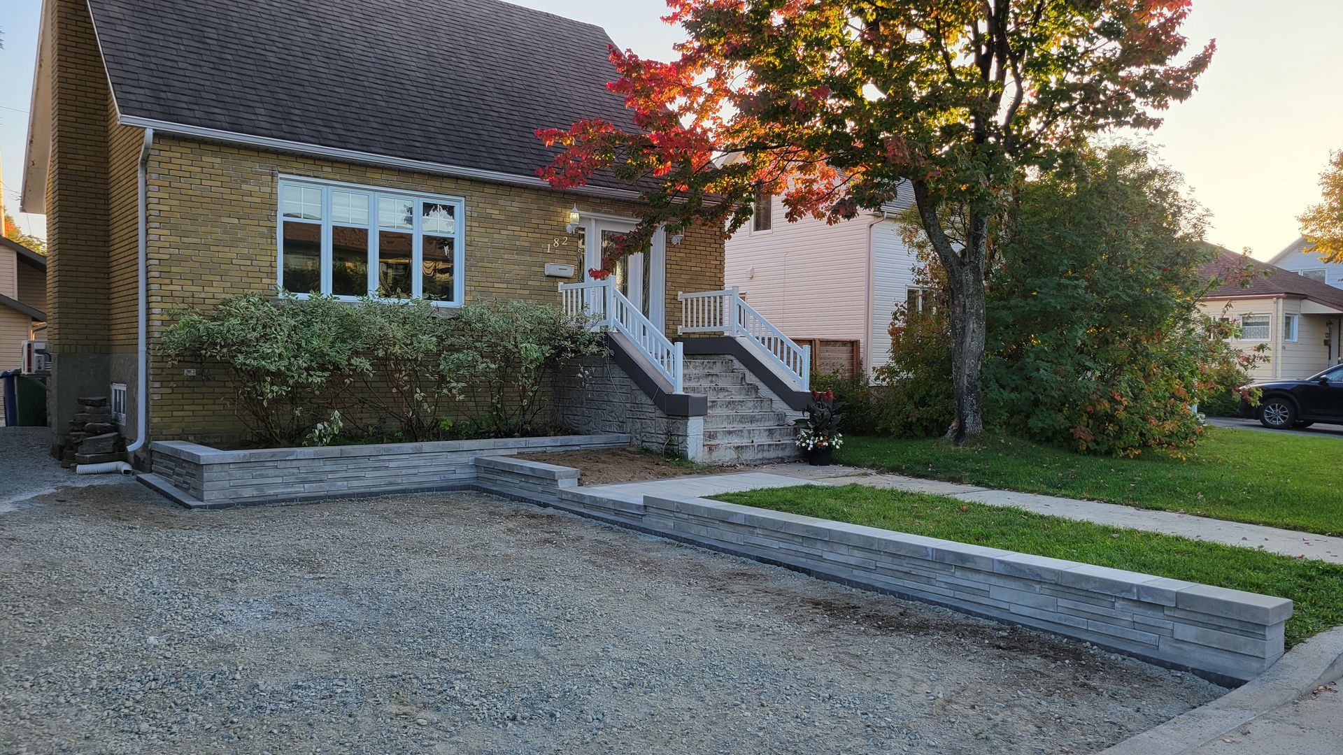 Une maison avec une allée de gravier devant elle.