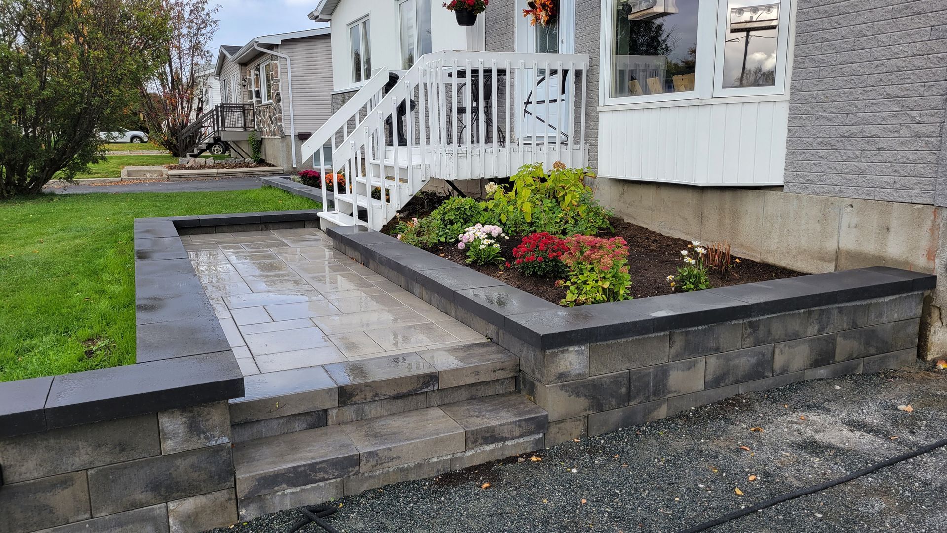 Une maison avec un escalier et un jardin devant.