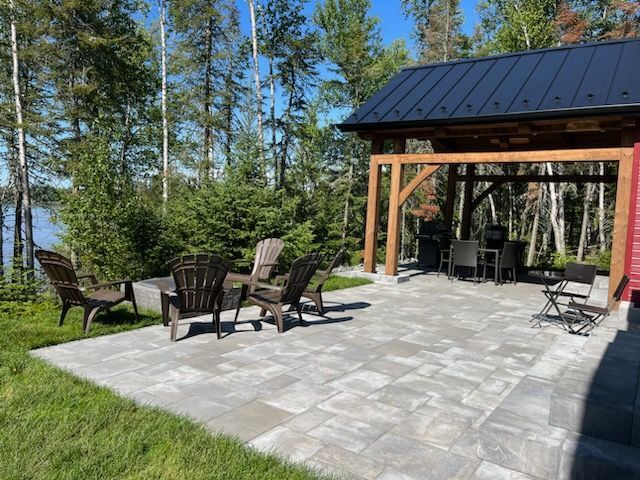 Un patio avec des chaises et un gazebo en arrière-plan.