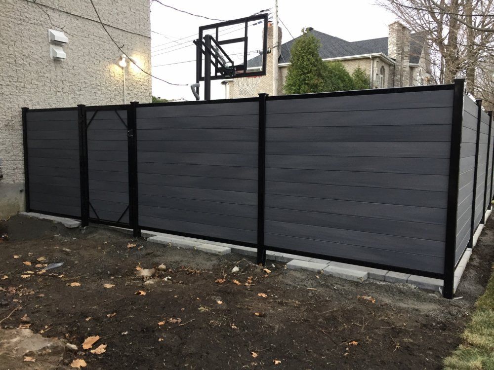 Une clôture noire avec un panier de basket en arrière-plan.