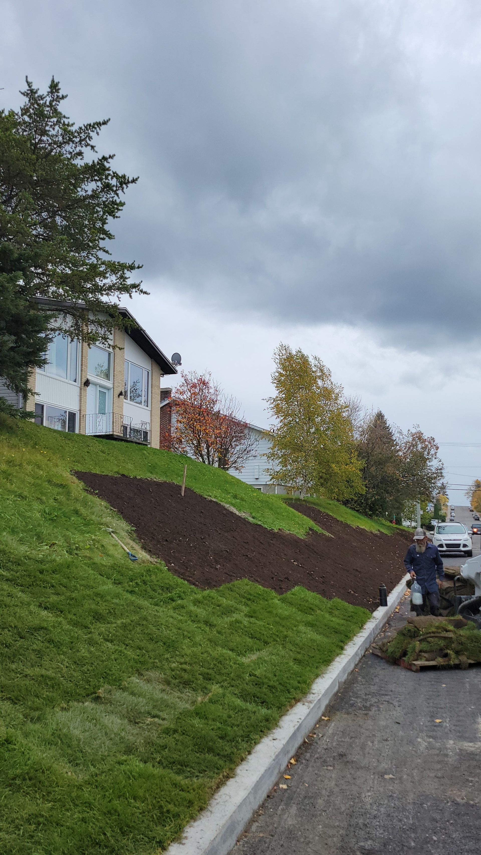 Une maison est en construction sur une colline à côté d'une route.