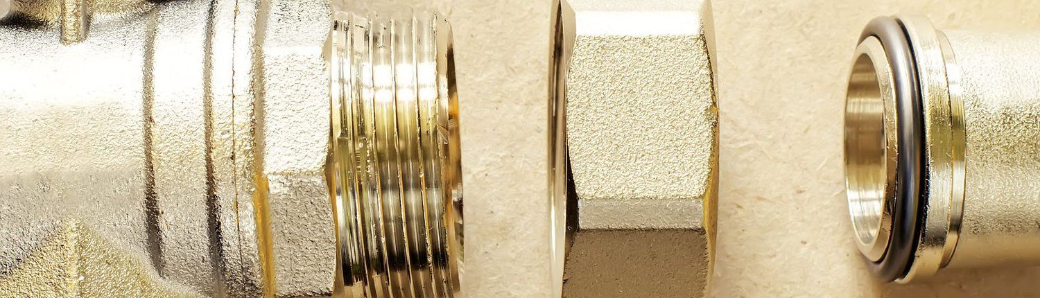 A close up of a brass nut on a metal pipe.