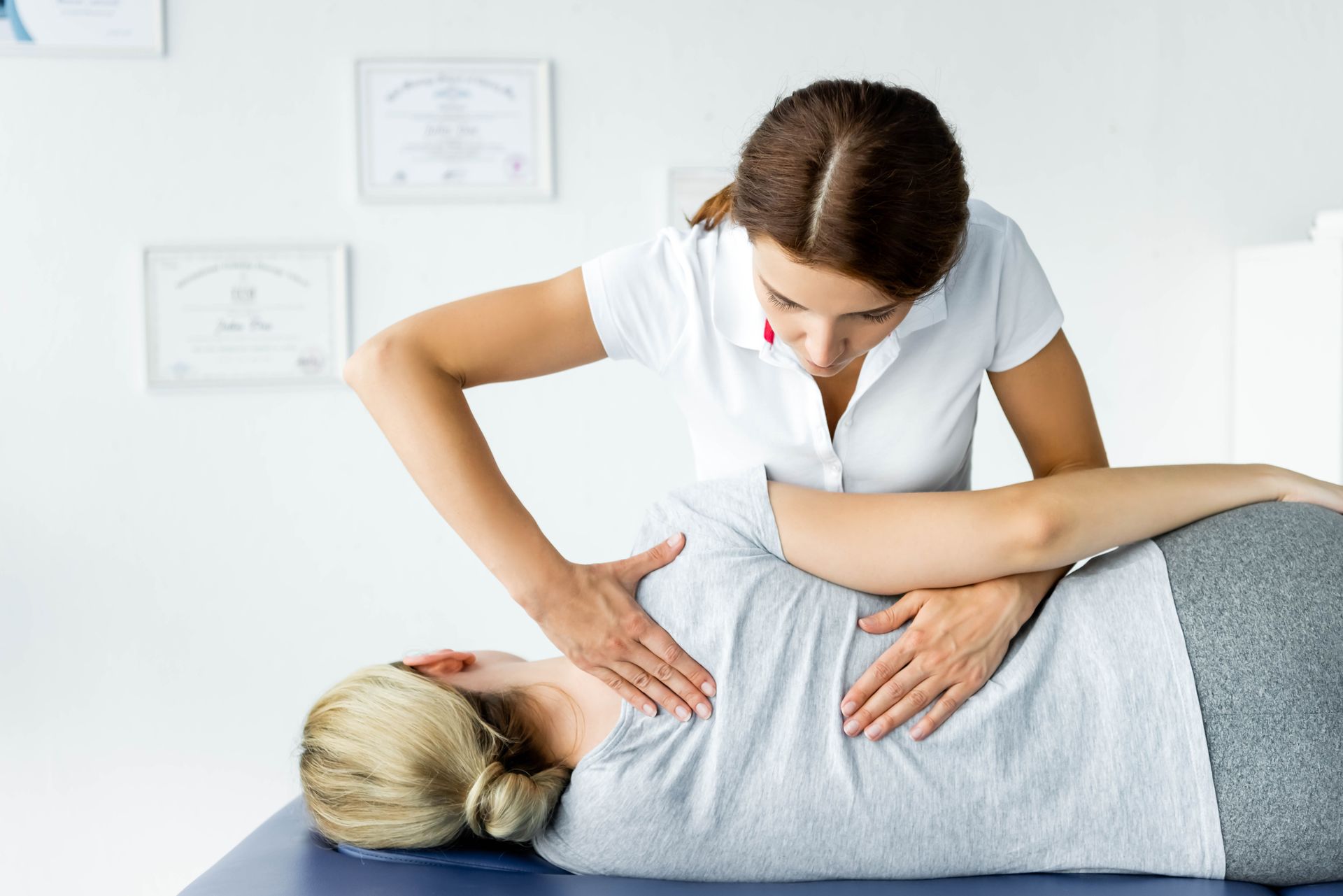 chiropractor making an adjustment to a patient's upper back