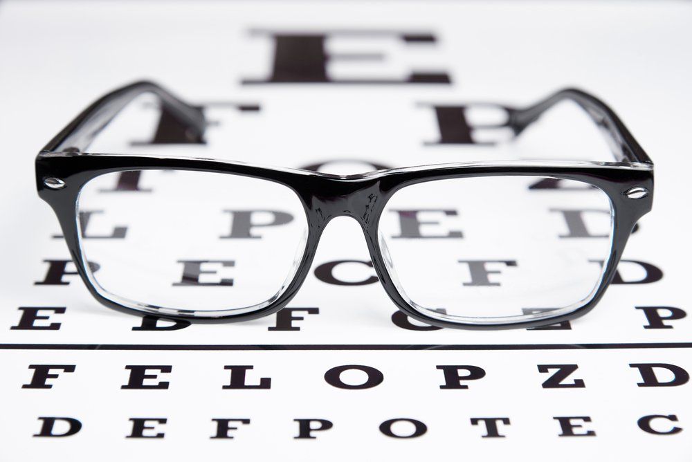 Prescription Glasses Sitting on Eye Test Chart - Optometrist Expert Care in Coconut Grove, NT