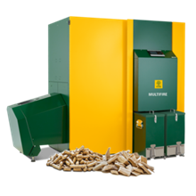 Accanto, una caldaia a biomassa verde e gialla con pellet e cippato. Sulla parte anteriore è scritto 