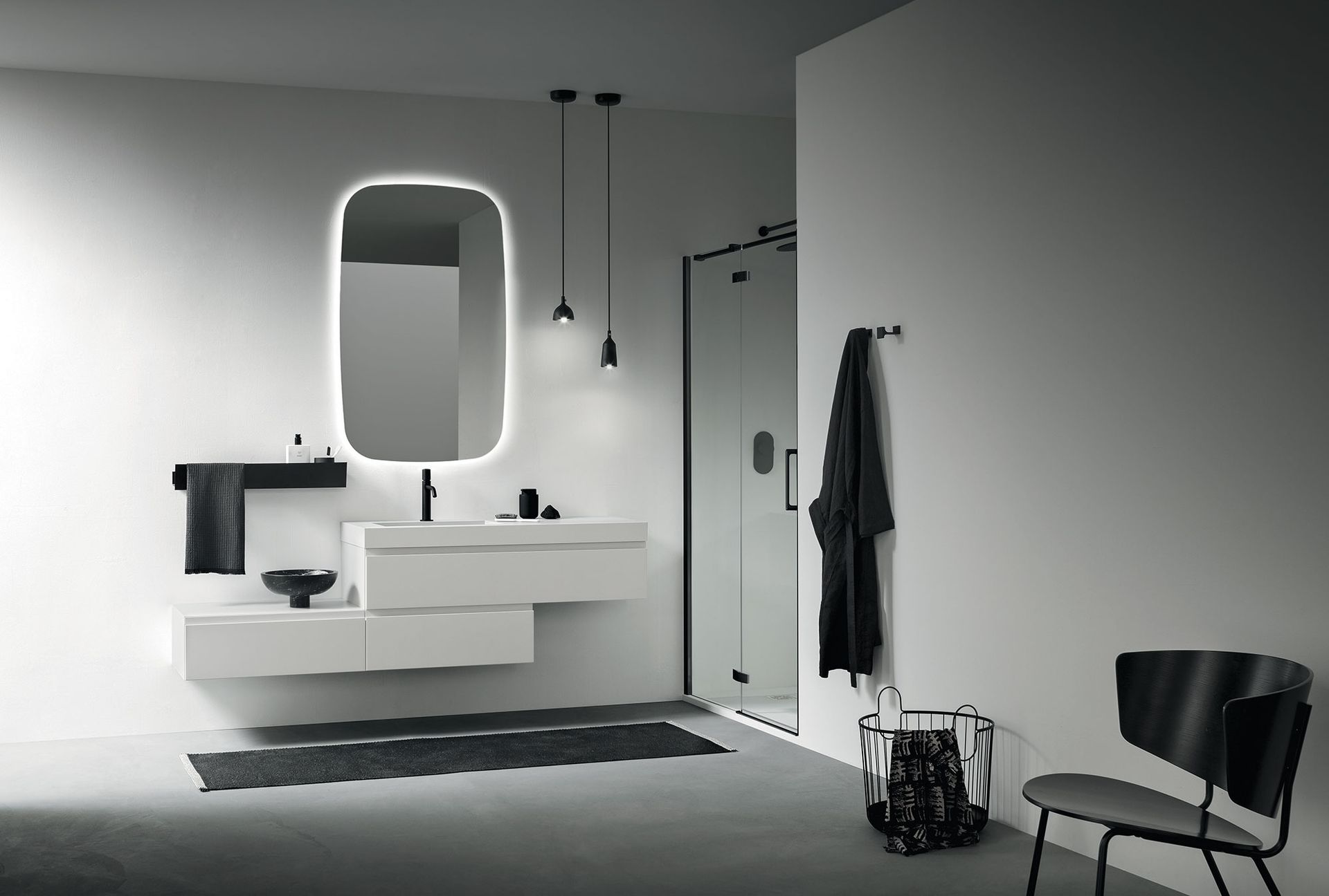 Bagno moderno e minimalista con mobile lavabo bianco sospeso, specchio illuminato e dettagli neri.