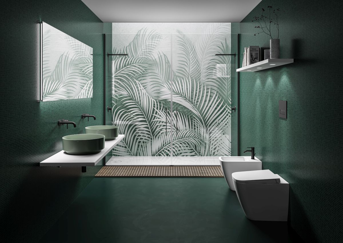 Bagno verde con parete doccia decorata con motivi a foglie, pareti verde scuro, lavandino bianco e WC.