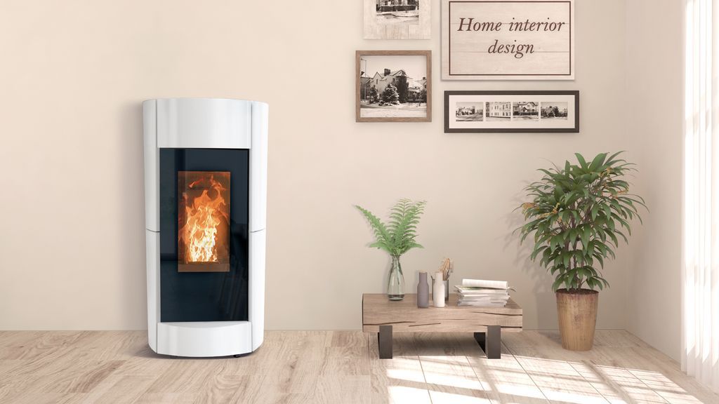 Una stufa a pellet bianca con fiamme, accanto a un tavolino con delle piante in una stanza luminosa.