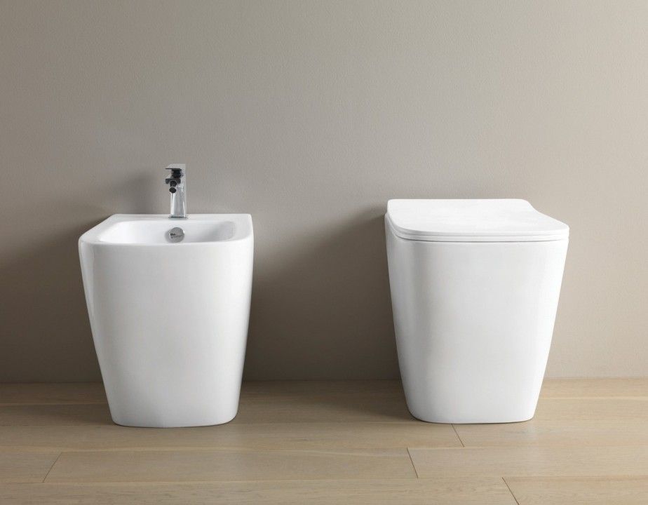 Rubinetto che versa acqua in un lavandino bianco in un bagno.