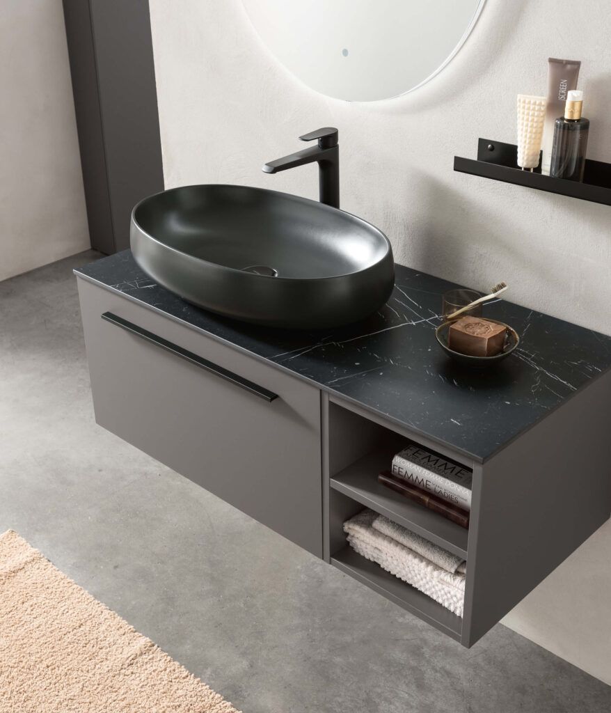Mobile lavabo sospeso grigio con piano d'appoggio nero e lavabo a appoggio. Mensole a giorno per gli asciugamani. Rubinetto nero.
