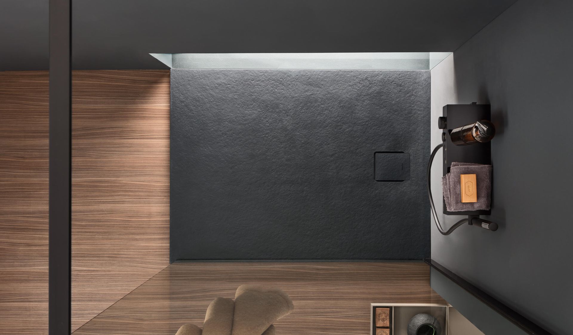 Vista dall'alto di un interno moderno con pannelli in legno, una parete grigio scuro e una parete nera testurizzata.