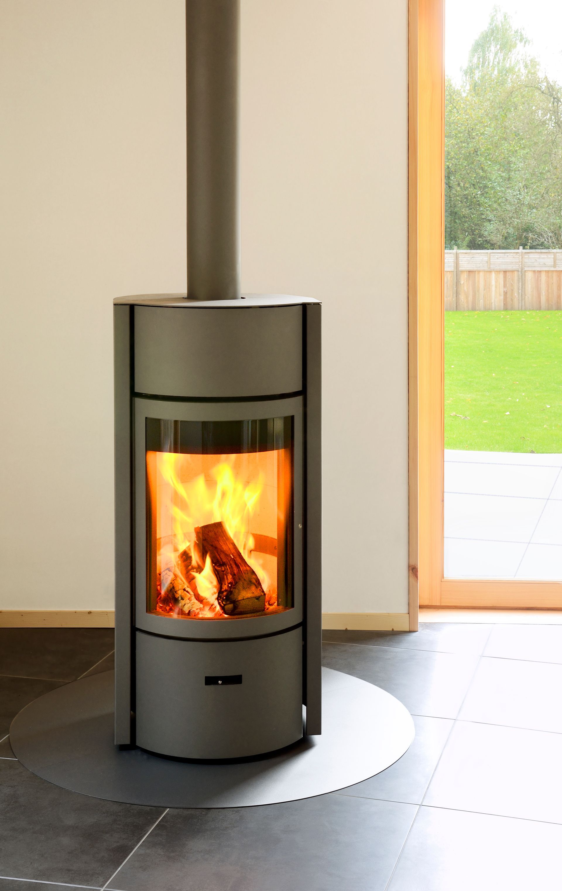 Un camino moderno con una donna che lo aziona con un telecomando, fiamme e un design in bianco e nero.