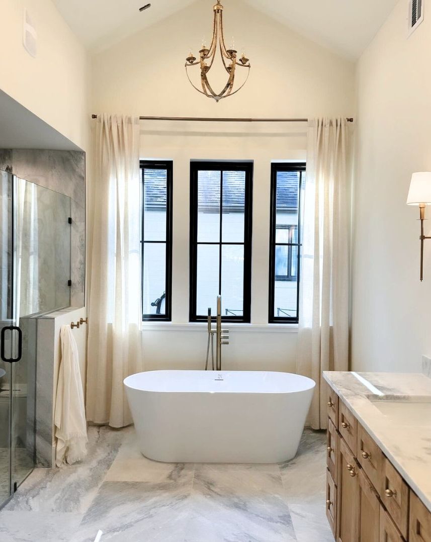 A bathroom with a bathtub and a chandelier hanging from the ceiling.