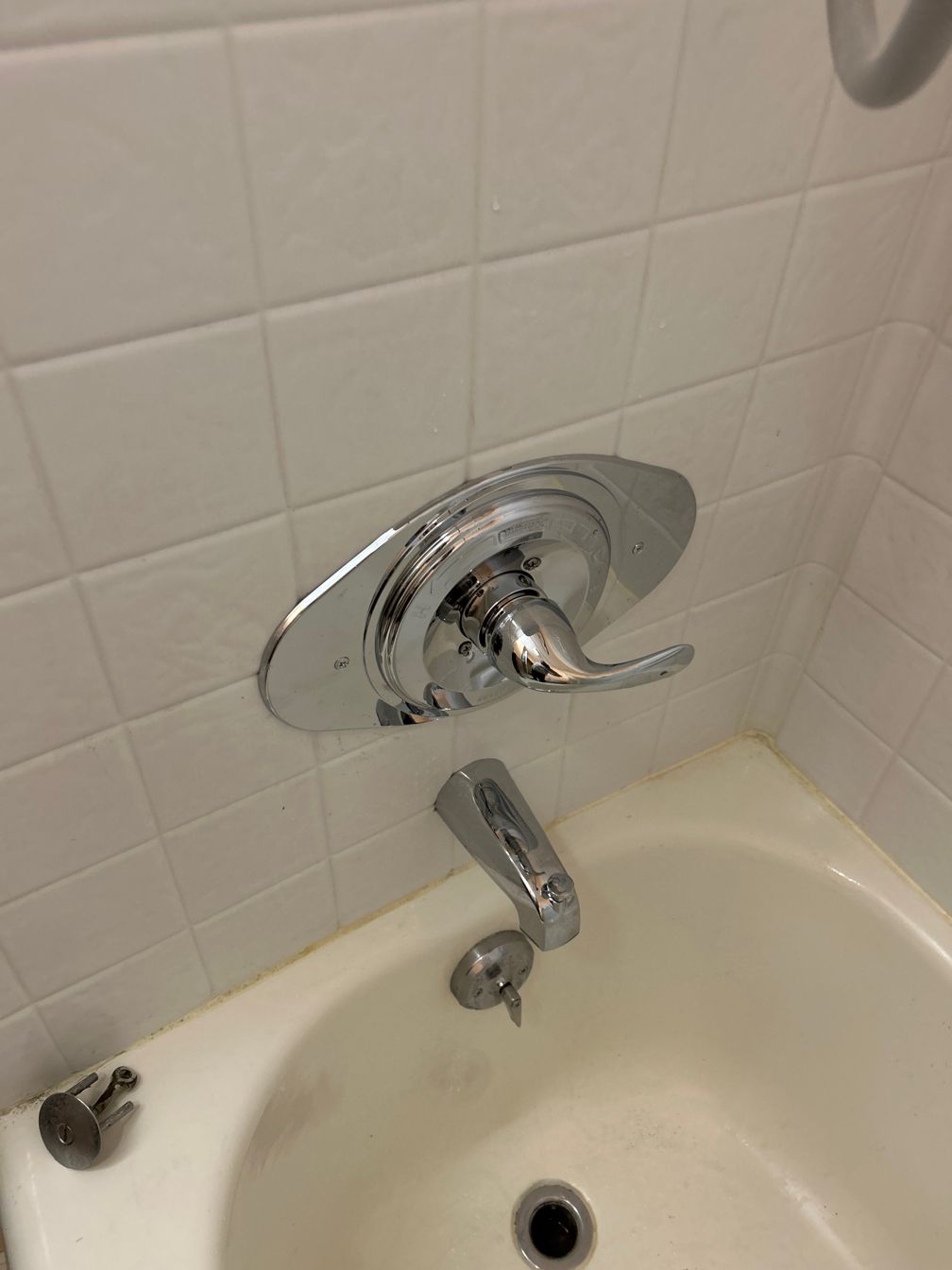 A bathtub with a chrome faucet on the wall