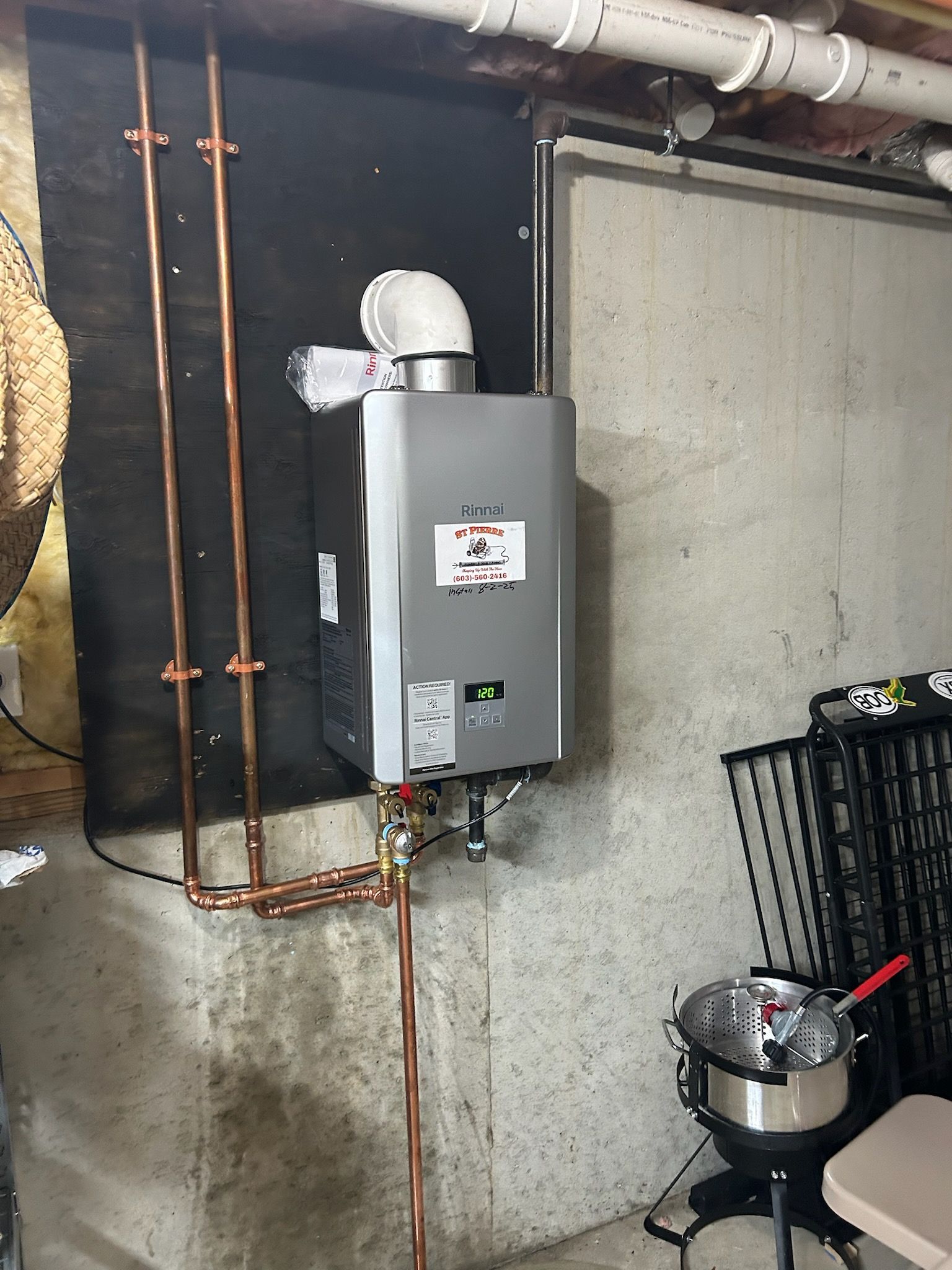 A water heater is attached to the side of a brick building.
