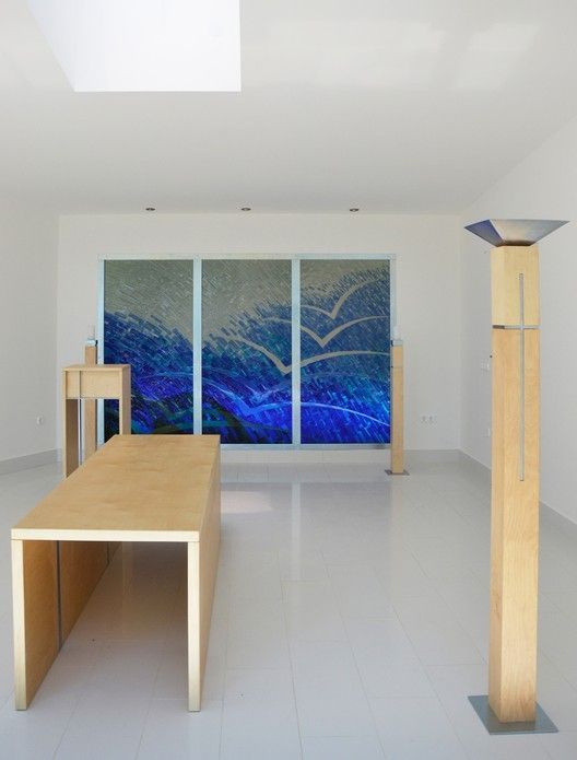 Modern meditation room with wooden benches, triptych ocean artwork, and clean minimalist design