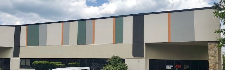 A large building with a lot of windows and a van parked in front of it.