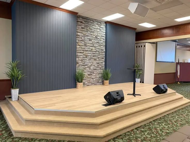 Church stage with stone accent wall and wooden platform for worship services.