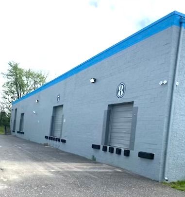 A large gray building with a blue roof and the number 8 on it
