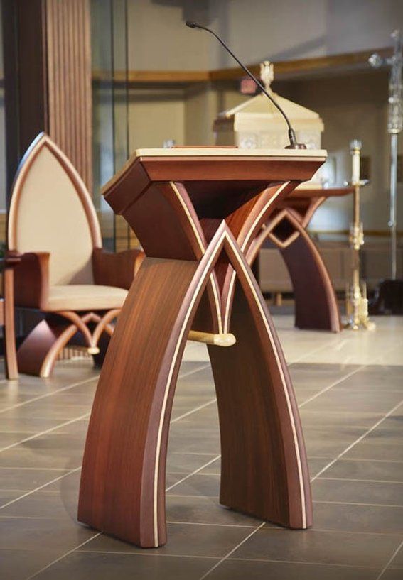 Contemporary church building with prominent wooden cross and A-frame design.