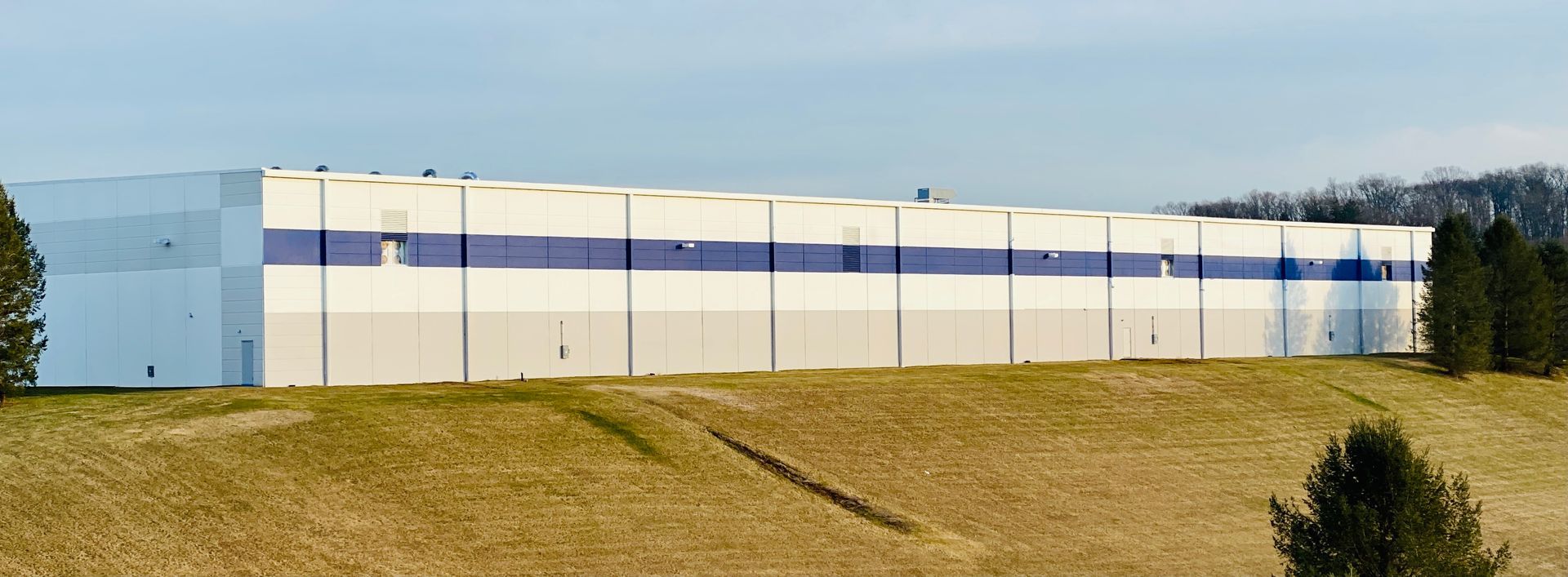 A large white building with blue stripes on the side