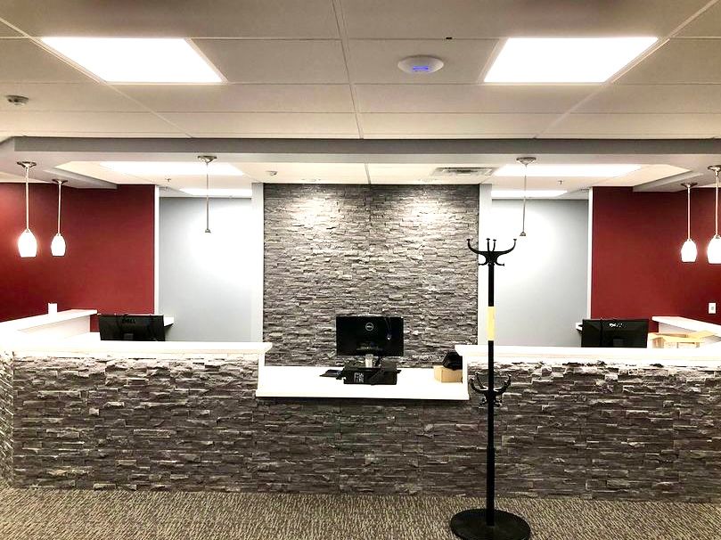 A reception area with a computer and a coat rack