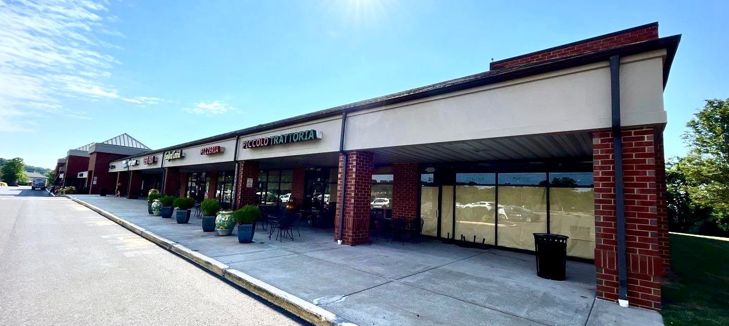 A large building with a lot of windows and a lot of plants in front of it.