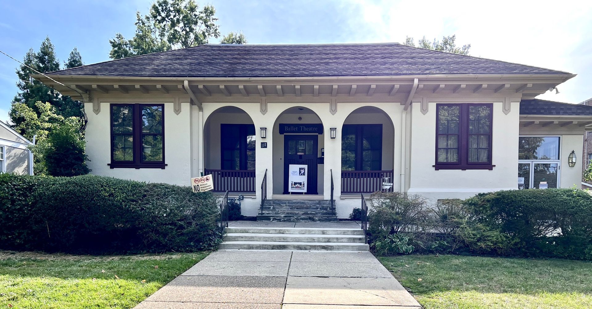 A white house with a sign in front of it that says for sale