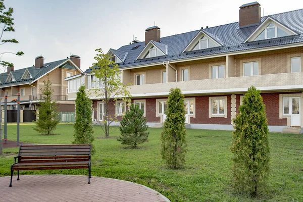 Senior living complex with landscaped grounds and bench seating area.