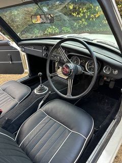 Interior view from the driver side of a white MGC GT 3 