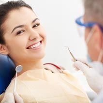 Dentist cleaning patient's teeth — Dental Services in Durham, NC