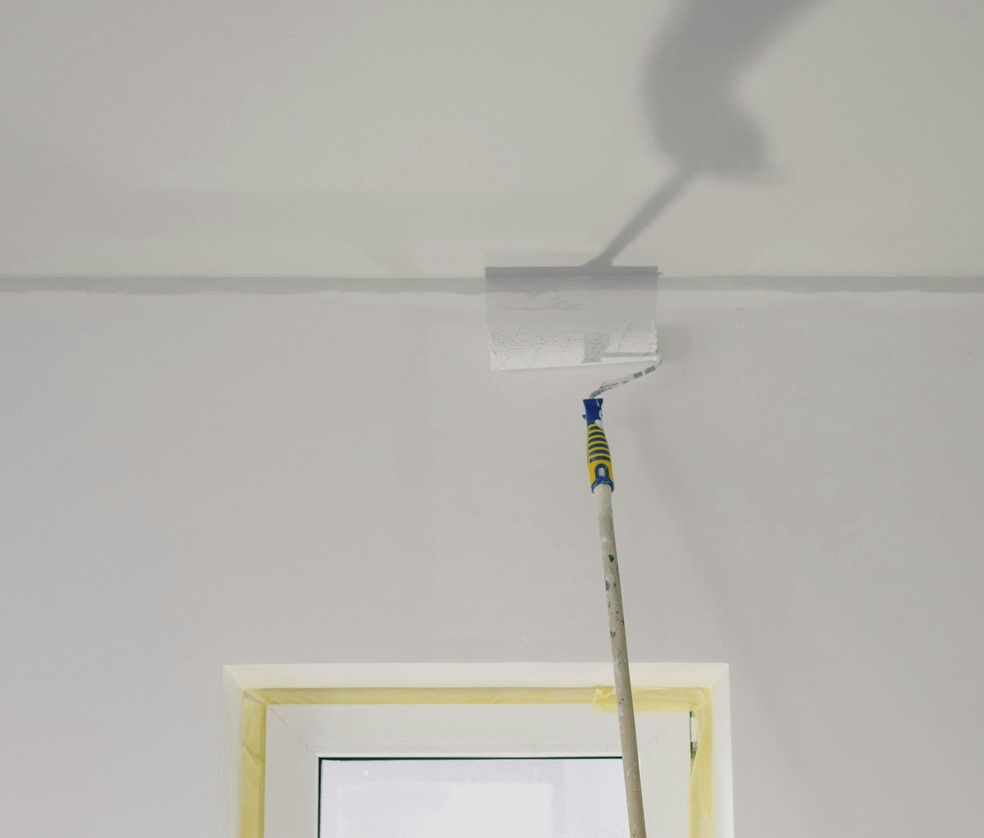 A man is painting a wall with a brush.