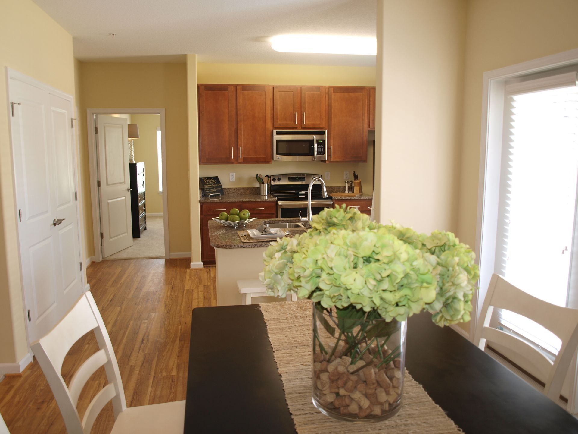 A dining room table with a vase of flowers on it