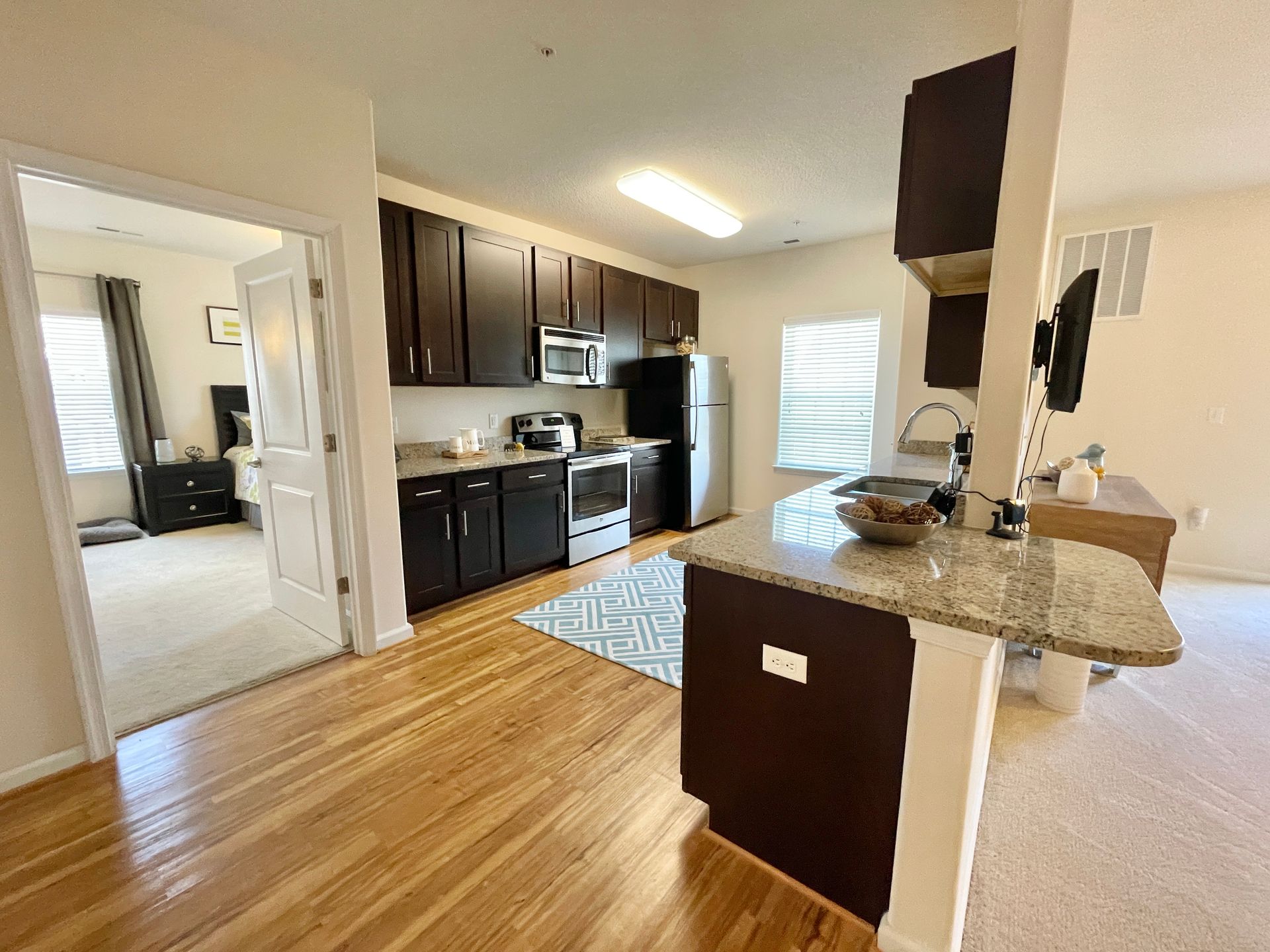 A kitchen with wooden floors and stainless steel appliances.