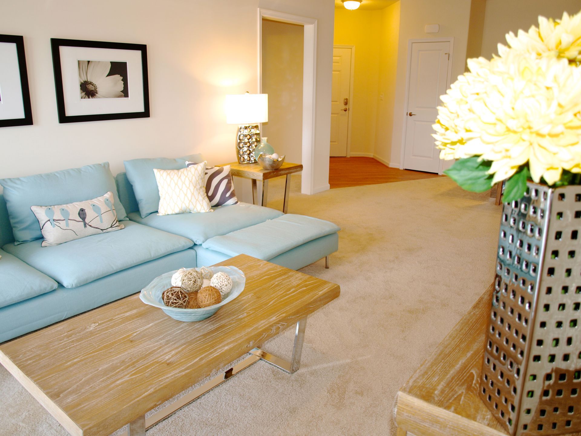 A living room with a blue couch and a wooden coffee table