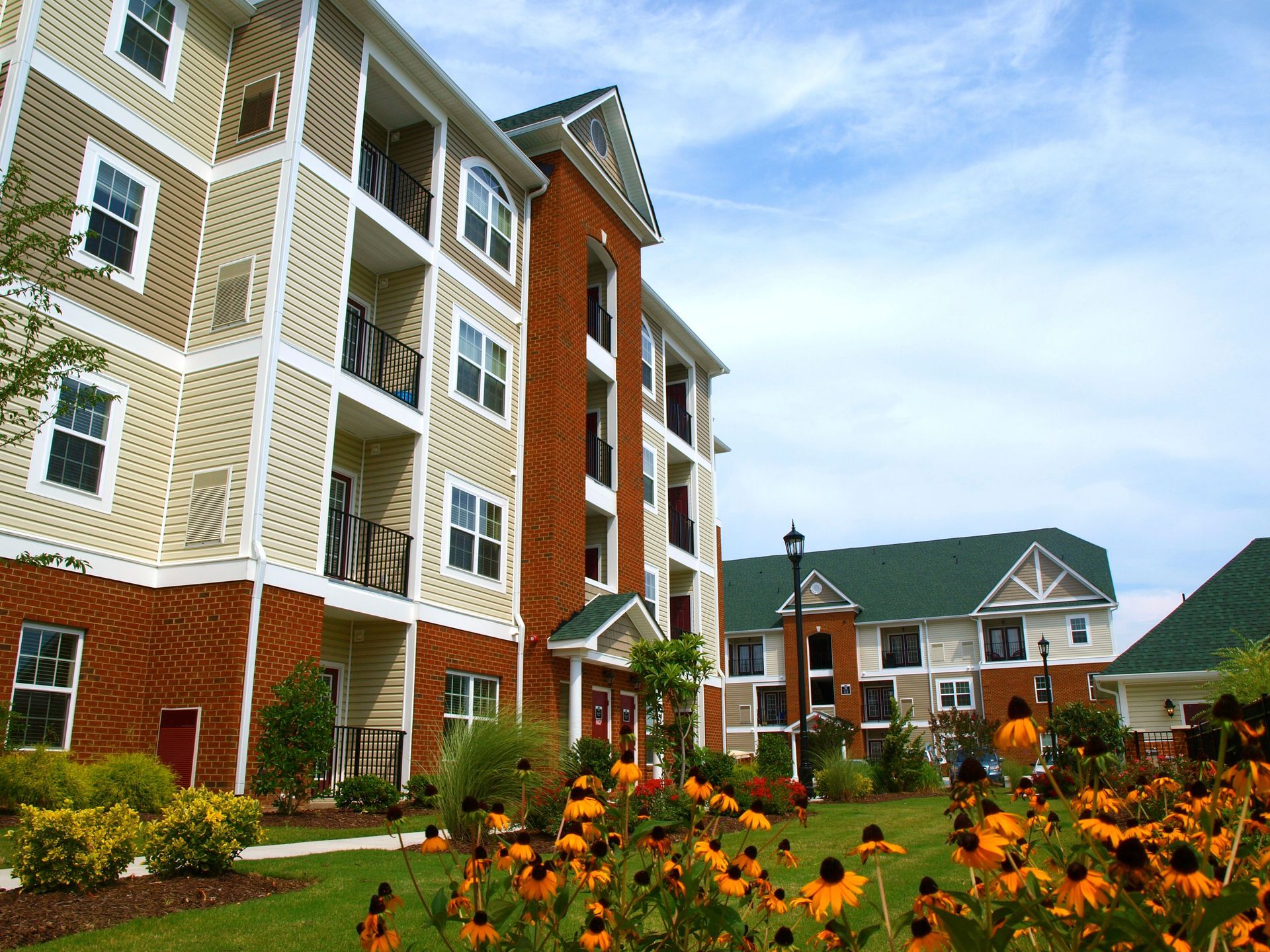A large apartment building with flowers in front of it
