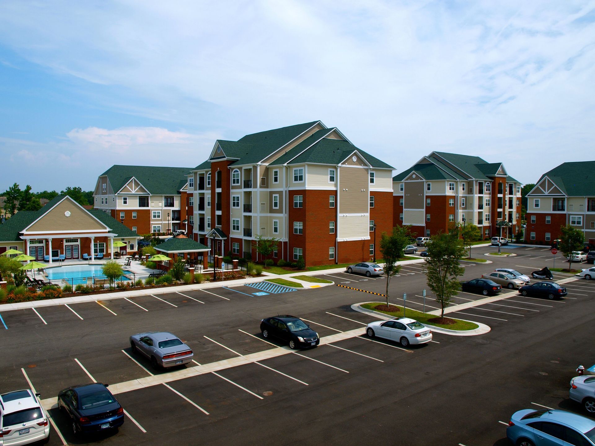 Cars are parked in front of a large apartment complex